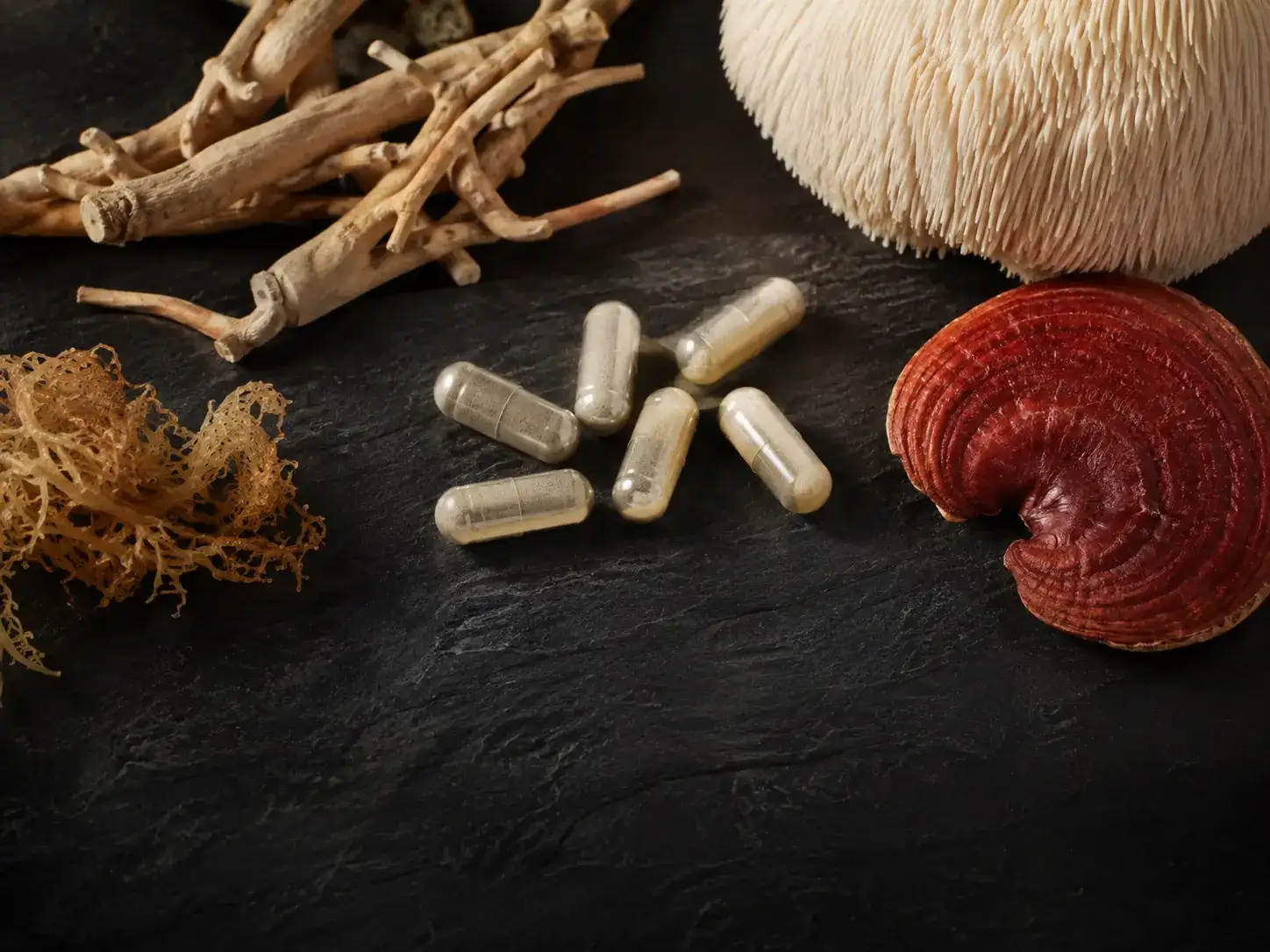 Unbranded dark capsules with restrained botanical ingredients on mineral stone.