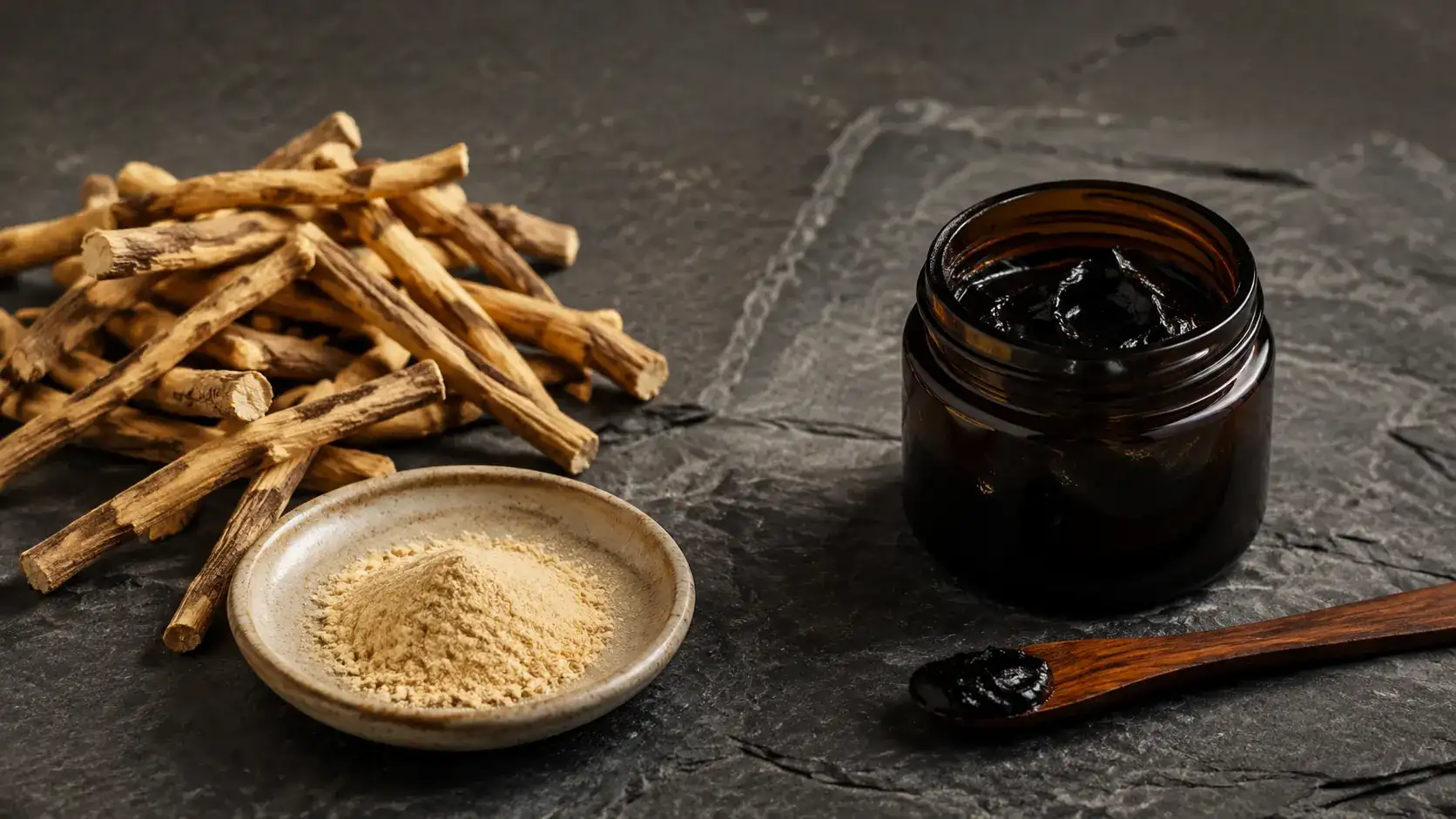 Ashwagandha roots, unbranded capsules and dark resin arranged on mineral stone.